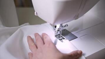seamstress makes an even stitch on the sewing machine. seamstress's experience allows her to do this quickly and efficiently. The seamstress's hands hold fabric precisely to achieve the best result. video