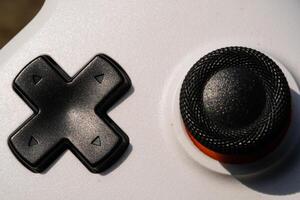 Black Directional Pad on a white Game controller. Directional pad is used to move focus up, down, right, and left in the user interface. Hobbies and leisures. Negative Space photo