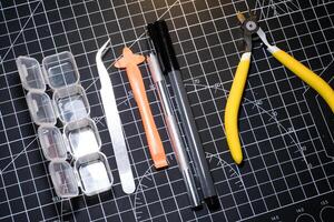 Set of hobby tools for building plastic model kits. Consisting of Nipper, Ink pen, cutting blade, plastic separator, tweezer, and transparent plastic container. Tools and equipments photo