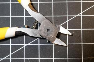 Closeup Nipper tools on black cutting mat. Nippers are used to cut small plastic parts. Pliers are used to cut. Model kit builder tools. Hobbies and leisures. Negative Space photo