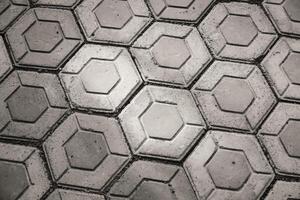 Monochrome hexagonal paving block exposed to morning sunlight. Black and white paving block neatly arranged. Hexagon pattern pavement outdoor texture. photo