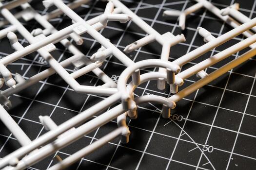 Stack of Plastic Frames on Black rubber cutting mat. Abstract Backgrounds of model kit frames. Part of plastic model kit and tools for building robot. Miniature and Object photo