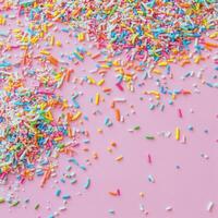 Colorful sprinkles on a pink background photo