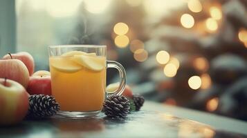 A glass of apple cider with pine cones and apples photo
