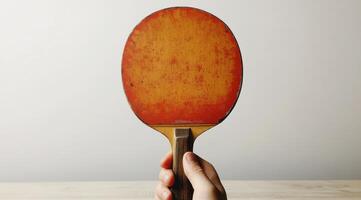 A person holding a ping pong paddle photo