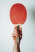 A person holding a ping pong paddle over a white background photo