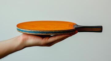 A person holding a ping pong paddle photo