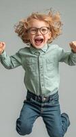 A little boy in glasses and a green shirt is jumping photo