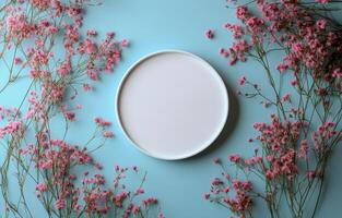 A white oval frame surrounded by pink flowers photo