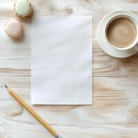 Blank paper, pencil and macarons on wooden table photo