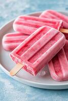 Popsicles on a plate with pink ice cream photo