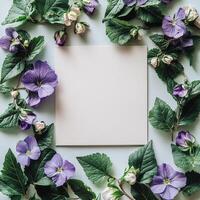 Flowers and leaves around a blank card on a blue background photo