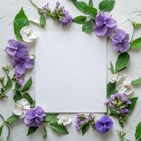A white square frame surrounded by purple flowers and green leaves photo