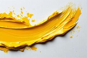 A yellow paint splashed on a white surface photo