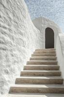 A white building with steps leading up to a door photo