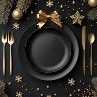 Christmas dinner table with gold and black plate, fork, knife and spoon photo