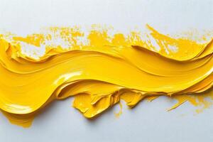 A yellow paint is being poured into a white surface photo