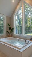 A large tub sitting in a bathroom with a window photo