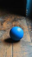 A blue egg sitting on a wooden floor photo