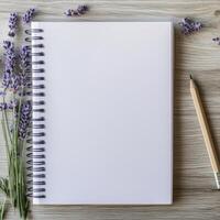 A blank notebook with lavender flowers and a pencil on a wooden table photo