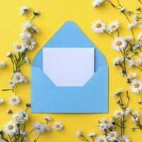 An open envelope with white paper and daisies on yellow background photo