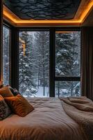 A bedroom with a bed and windows overlooking a snowy forest photo