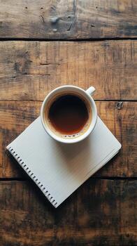 café taza en un cuaderno en un de madera mesa foto