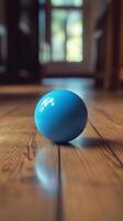 A blue egg sitting on a wooden floor photo
