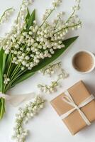 Lily of the valley flowers and gift box on white background photo