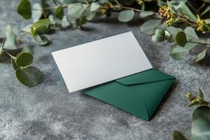 Green envelope with blank card on concrete background photo