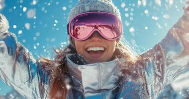 A woman in a ski jacket and pink goggles is smiling photo