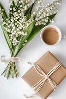 Lily of the valley flowers and gift on white background photo