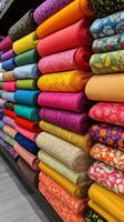 A large pile of colorful fabric on a shelf photo