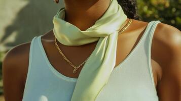 A woman wearing a green scarf and gold chain photo