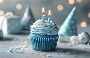 Blue birthday cupcake with two candles on top photo