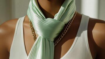 A woman wearing a green scarf and gold chain photo