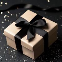 Gift box with black ribbon and gold glitter on black background photo