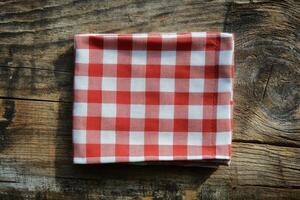 A red and white checkered napkin on a wooden table photo