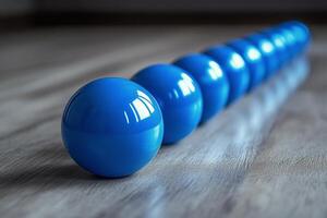Blue balls in a row on a wooden floor photo