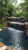 A waterfall in a tropical garden with a pool photo