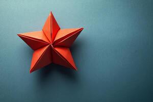 A red origami star on a blue background photo