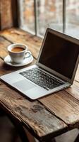 Laptop and coffee on wooden table photo