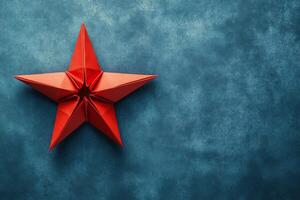 A red origami star on a blue background photo