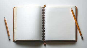 Open notebook with pencils on white background photo