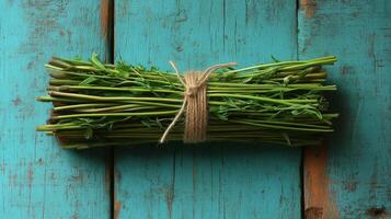 Bunch of herbs tied with twine on a blue wooden table photo