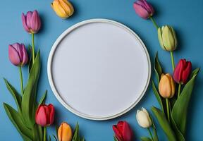 Colorful tulips and an oval frame on a blue background photo