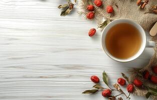 Cup of tea and goji berries on white wooden table top view photo