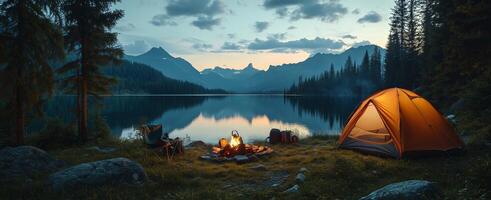 A tent is set up near a lake and mountains photo