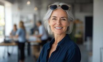 A woman with glasses smiling in an office photo