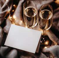 Two glasses of champagne with a blank card on a blanket photo